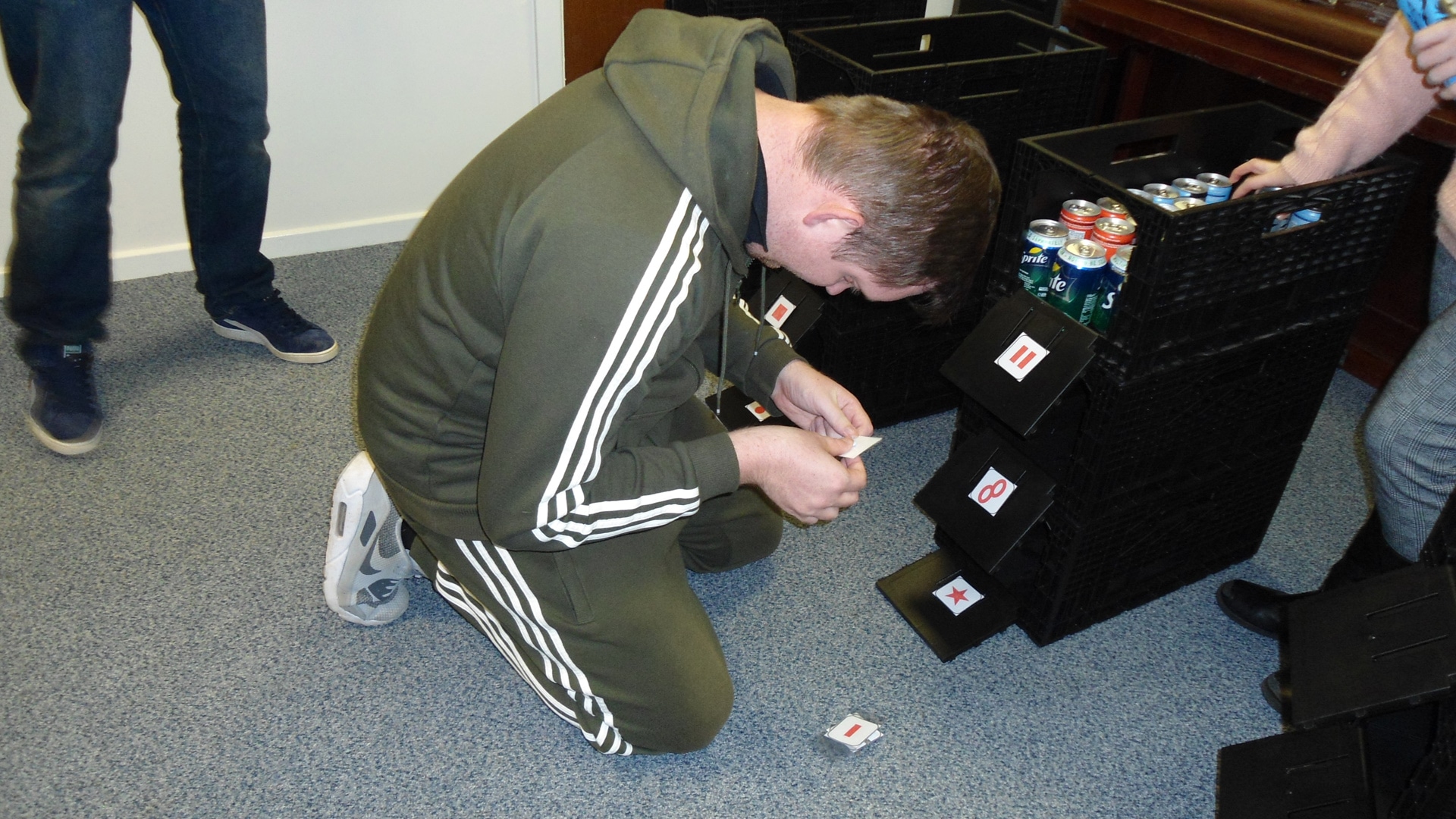 Magpies member looking at labels on crates of fizzy drinks